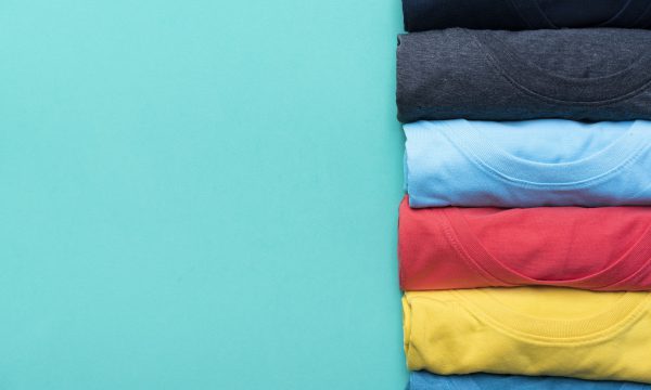 Close Up Of Rolled Colorful Clothes On Green Background