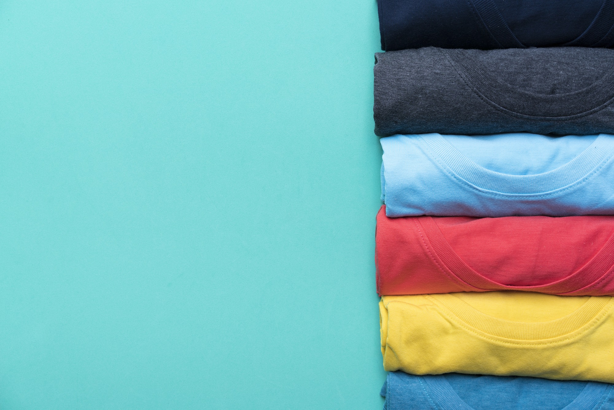 Close Up Of Rolled Colorful Clothes On Green Background